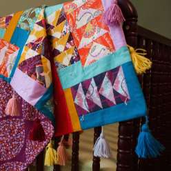 Anna Maria Horner puts a fresh spin on the traditional Flying Geese design with this baby quilt. She explains how she chooses solid and prints, lights and darks, and how she pairs different prints to add depth and pop to each block. 