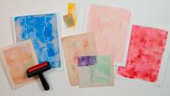 An assortment of decorative papers and a brayer from Dawn M Cardona's Make Painted Papers for Art Making class on Creativebug