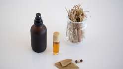 A spray bottle, a sample of natural perfume, and a beaker of botanicals from the Make Natural Perfume class on Creativebug, taught by Arina Solar
