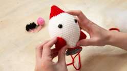 A pair of hands holding a stuffed crocheted rocket ship from Vincent Green-Hite's Crochet an Amigurumi Rocketship Creativebug class