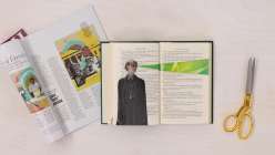 An overhead spread of an open book with a black and white image of a woman on the left and a bright green beam of light projecting from her eyes in Creativebug's Altered Books Daily Practice class