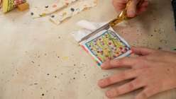 A pair of hands trimming a piece of embroidery in from Rebecca Ringquist's Embroidered Botanical Pattern Weights Creativebug class