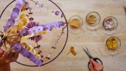 A straw, wood, and purple tissue paper decorative Polish paper pajaki made by Mia Semingson of Two Hands Paperie in her Make Paper Pajaki Creativebug class