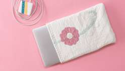 A floral-appliqued quilt made into a laptop sleeve from Heidi Parkes's Sew a Quilted Laptop Slipcase class on Creativebug