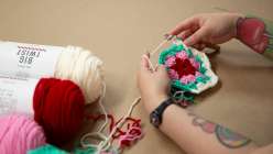 A still of hands crocheting a four-color granny hexagon from Twinkie Chan's from Twinkie Chan's Crochet an Heirloom Granny Hexagon Stocking class on Creativebug