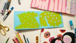 An open sketchbook surrounded by art supplies from Rebecca Ringquist's Magpie Sketchbook class on Creativebug.