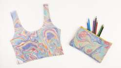 A crop top and pencil pouch marbled in Mercedez Rex's Marbling Finished Goods class on Creativebug.