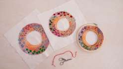 A circular embroidery in progress next to a finished example of an all-seasons embroidered wreath, made in Rebecca Ringquists's class on Creativebug.