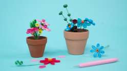 Two small terracotta pots with quilled flowers made in Nikki Furlong's Paper Quill Mini Potted Flowers class on Creativebug